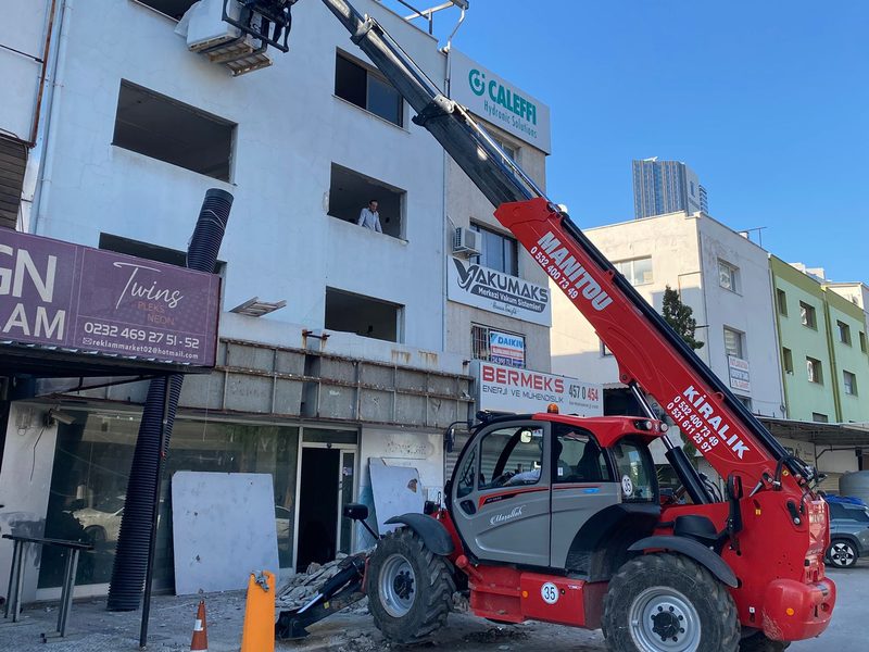 İzmir'de dar bir cadde üzerinde binaya malzeme çıkaran Manitou teleskopik yükleyici